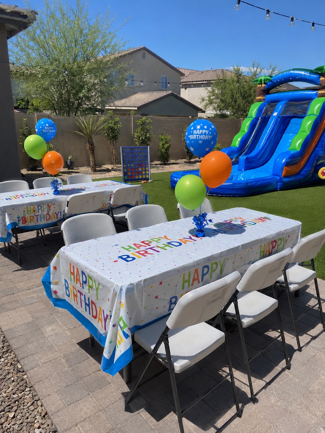 Rectangular event tables shown with white folding chairs at a backyard birthday