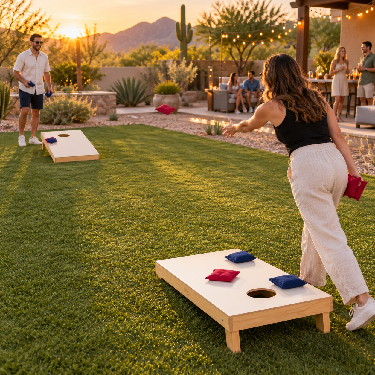 Adults playing cornhole on a correctly aligned two-board court at an Arizona backyard event